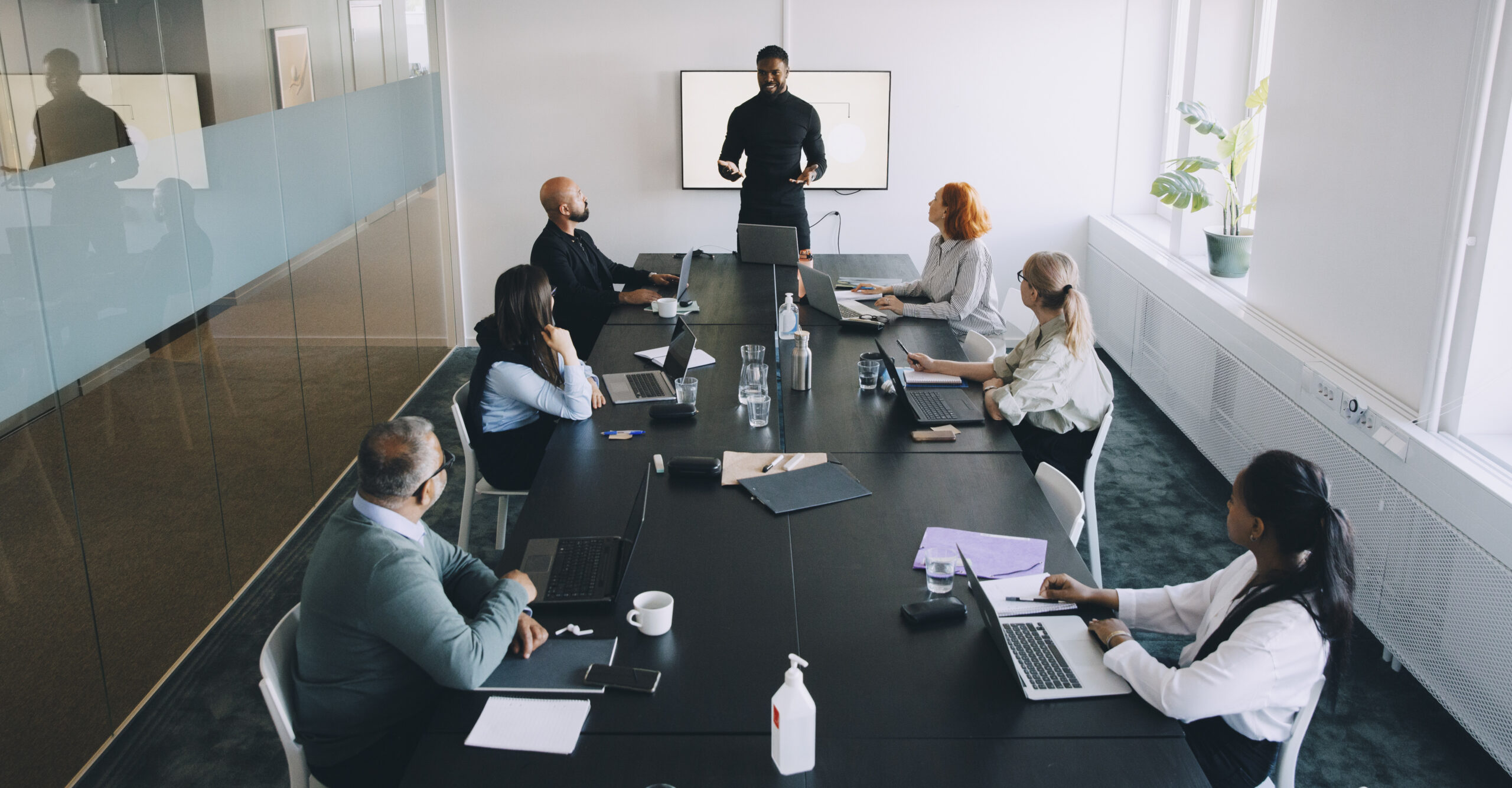 High angle view of businessman giving presentation colleagues in board room at office